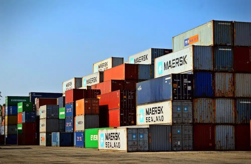 Stacked shipping containers in organized rows at cargo yard facility