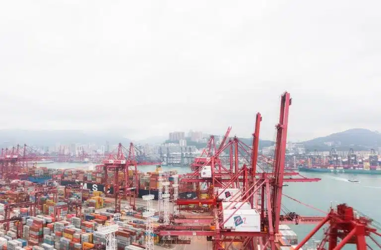 Large container port with red cranes managing shipping yard operations